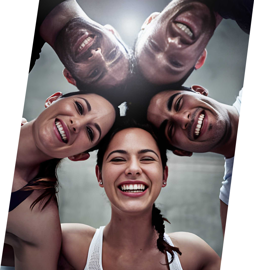 Four happy team members looking down at the camera in a circle, smiling broadly