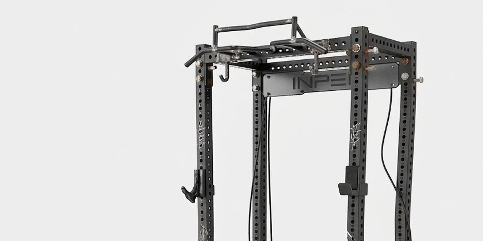 Black and white image of a gym equipment frame showing damage from improper assembly