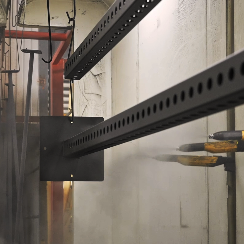 Black metal frame parts hanging in a factory