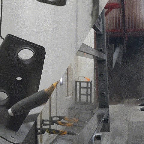 Black metal frame parts hanging in a factory