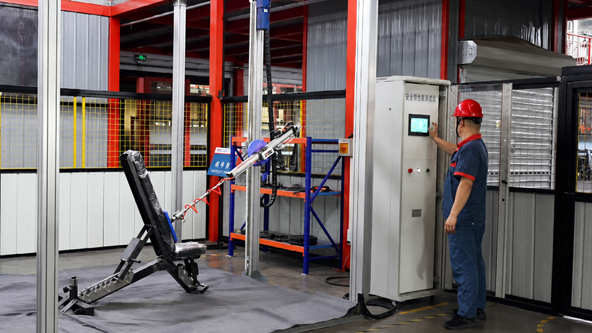 Testing machine applying force to a piece of gym equipment